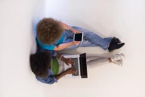 couple multiethnique assis sur le sol avec une vue de dessus d'ordinateur portable et de tablette