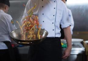 chef retournant les légumes au wok photo