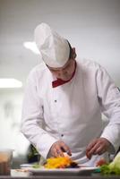 chef dans la cuisine de l'hôtel préparant et décorant la nourriture photo