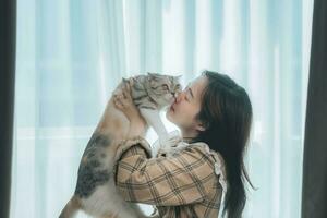 closeup portrait belle jeune femme hipster, embrasse son bon ami gingembre chat sur fond de mur blanc. émotions humaines positives, expression faciale, sentiments. les gens et les animaux amoureux photo