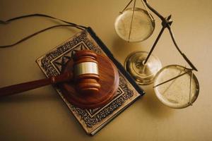 concept de justice et de droit. juge masculin dans une salle d'audience avec le marteau, travaillant avec, clavier d'ordinateur et d'accueil, lunettes, sur table à la lumière du matin photo