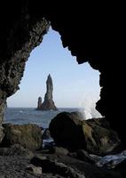 Vagues venant à la plage noire de Reynisfjara, Islande, avec des formations rocheuses en arrière-plan photo