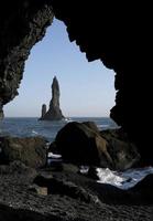 Vagues venant à la plage noire de Reynisfjara, Islande, avec des formations rocheuses en arrière-plan photo