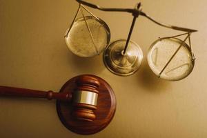 concept de justice et de droit. juge masculin dans une salle d'audience avec le marteau, travaillant avec, clavier d'ordinateur et d'accueil, lunettes, sur table à la lumière du matin photo