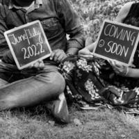 couple indien posant pour une séance photo de maternité. le couple pose dans une pelouse avec de l'herbe verte et la femme étale sa bosse de bébé dans le jardin de lodhi à new delhi, inde - noir et blanc