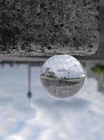 Vue inversée de Düsseldorf dans une boule de cristal sur un mur de pierre photo