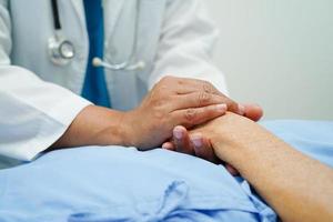 médecin tenant par la main une patiente âgée asiatique, aide et soins à l'hôpital. photo