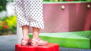 pieds d'enfant dans une aire de jeux, les jambes des filles grimpent sur l'équipement de terrain de jeu à l'aire de jeux extérieure. les enfants actifs s'amusent. espace vide pour saisir du texte. photo