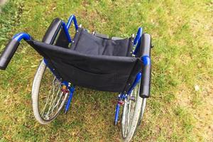 fauteuil roulant vide debout dans le parc de l'hôpital en attente de services aux patients. fauteuil roulant pour personne handicapée garé à l'extérieur. accessible pour personne handicapée. concept médical de soins de santé. photo