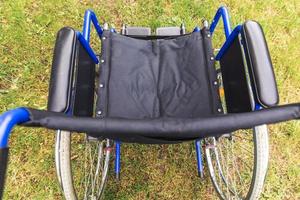 fauteuil roulant vide debout dans le parc de l'hôpital en attente de services aux patients. fauteuil roulant pour personne handicapée garé à l'extérieur. accessible pour personne handicapée. concept médical de soins de santé. photo