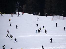 de nombreux skieurs skiant dans les montagnes de neige de la vallée de Gardena dolomites photo