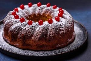 Délicieuse tarte de noël ronde faite maison avec des baies rouges sur une plaque en céramique photo