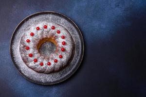 Délicieuse tarte de noël ronde faite maison avec des baies rouges sur une plaque en céramique photo