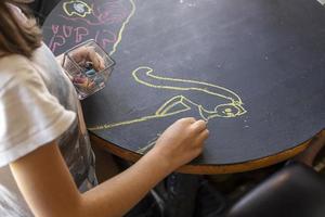 enfant dessinant sur une table de tableau dans un restaurant photo