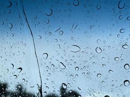 perspective de gouttelettes d'eau à travers la surface du verre contre le ciel bleu bon pour les arrière-plans de contenu multimédia photo