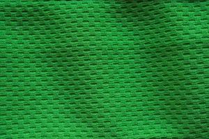 maillot de football de vêtements de sport en tissu vert avec fond de texture en maille d'air photo