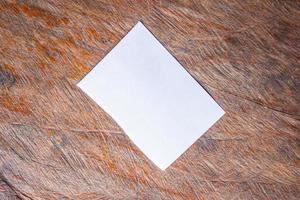 papier blanc vierge sur le vieux fond de table en bois rustique photo