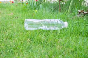 bouteille en plastique sur fond d'herbe verte concept de recyclage et de pollution photo