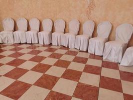 beaucoup de chaises couvertes de blanc de mariage photo
