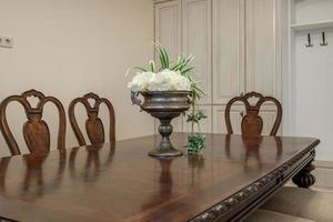 table servie dans le salon ou la cuisine avec tasses, assiettes, verres et fleurs photo