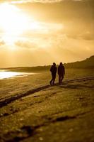 silhouette homme et femme sur la plage au lever du soleil photo