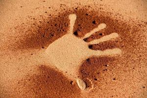 forme de main de sol rouge sur le sable comme le style d'art aborigène photo