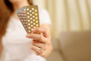 mains de femme ouvrant des pilules contraceptives à la main. manger la pilule contraceptive. la contraception réduit le concept d'accouchement et de grossesse. photo