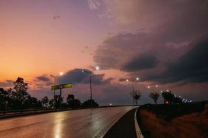 route éclairée par des lampes au beau coucher de soleil photo
