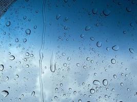 perspective de gouttelettes d'eau à travers la surface du verre contre le ciel bleu bon pour les arrière-plans de contenu multimédia photo