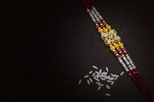un élégant rakhi, bracelet indien traditionnel sur fond noir photo