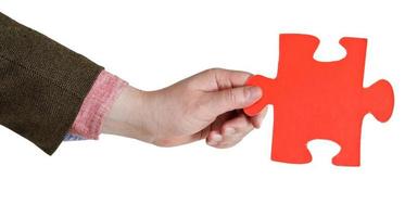 main masculine tenant une grande pièce de puzzle en papier rouge photo