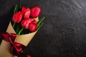 bouquet de tulipes rouges sur fond noir texturé photo