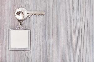 clé avec porte-clés sur fond de bois photo