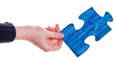 main féminine avec pièce de puzzle peinte en bleu photo