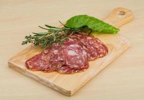 salami sur planche de bois et fond en bois photo