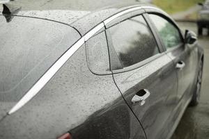 voiture premium noire. transporter en gouttes de pluie. photo