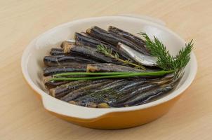 anchois salé dans un bol sur fond de bois photo