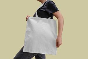 Femme tenant un sac fourre-tout en tissu pour maquette photo
