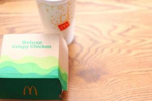 washington amérique 17 juin 2022 mcdonald's deluxe croustillant poulet burger box en papier recyclé avec un verre de pepsi. photo