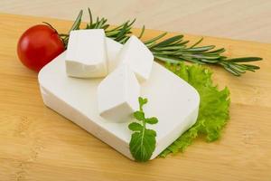 Fromage feta sur planche de bois et fond de bois photo