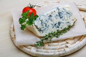 Fromage bleu sur planche de bois et fond de bois photo