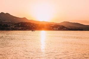 silhouette de bateau sur la mer au coucher du soleil photo