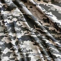 tissu avec une texture de camouflage pixélisé militaire ukrainien. tissu avec motif camouflage en formes de pixels gris, marron et vert. uniforme officiel des soldats ukrainiens photo