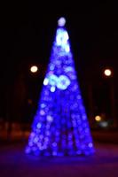 photo floue de l'arbre du nouvel an. beaucoup de lumières rondes en bleu