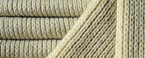 composition d'un pull en tricot jaune doux. texture macro des reliures en fils photo