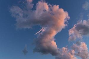 paysage nuageux. cumulus d'été roses et bruns sur un ciel bleu pendant le coucher du soleil. fond d'écran. Contexte. photo