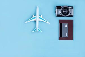 miniature d'avion comme symbole de voyage. appareil photo et passeport, accessoires de voyage, carte de crédit pour payer un séjour confortable.