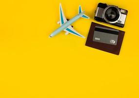 miniature d'avion comme symbole de voyage. appareil photo et passeport, accessoires de voyage, carte de crédit pour payer pour un séjour confortable