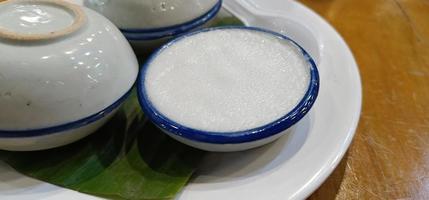 gros plan crème au lait de coco thaïlandais ou khanom thai dessert thaïlandais dans une tasse au goût sucré et crémeux sur le dessert thaïlandais photo