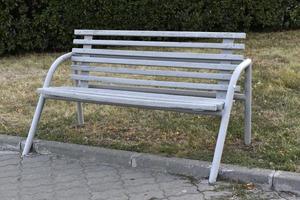 banc en bois dans un parc d'été de la ville. gros plan de banc dans l'après-midi. photo